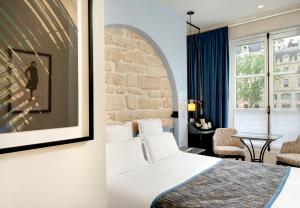 ein Hotelzimmer mit einem Bett und einem Tisch in der Unterkunft Les Rives de Notre-Dame in Paris