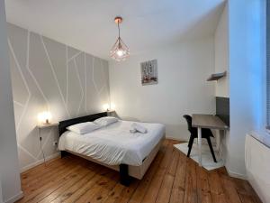 a small bedroom with a bed and a desk at LE VICTOR HUGO - Wifi - Centre ville - PROPERTY RENTAL NM in Périgueux