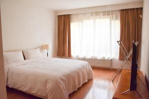 Postel nebo postele na pokoji v ubytování Belgravia Serviced Residence Wuxi