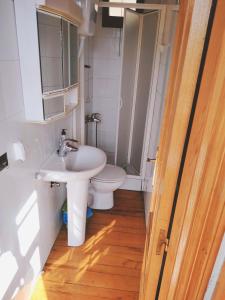 a bathroom with a white sink and a toilet at Casa Fidel. in Seoane