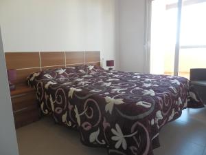 a bedroom with a bed with a black and white blanket at Apartment La Isla Terrazas de la Torre in Roldán