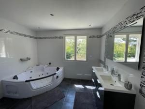 łazienka z dużą wanną i 2 umywalkami w obiekcie Maison tout confort en Touraine 4 chambres w mieście Fondettes