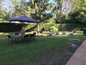 stół, krzesła i parasol na dziedzińcu w obiekcie Maison tout confort en Touraine 4 chambres w mieście Fondettes