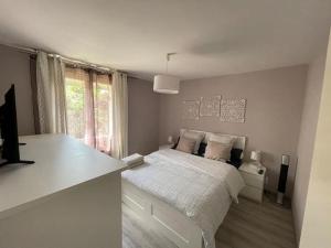 biała sypialnia z łóżkiem i oknem w obiekcie Maison tout confort en Touraine 4 chambres w mieście Fondettes