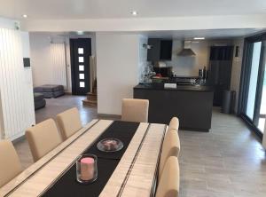 a dining room table with chairs and a kitchen at Maison tout confort en Touraine 4 chambres in Fondettes