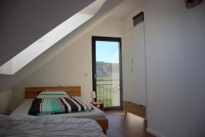 a bedroom with a bed and a large window at Gästehaus Casa Luna - Paradiesische Ferienwohnungen am Kaiserstuhl! in Bischoffingen