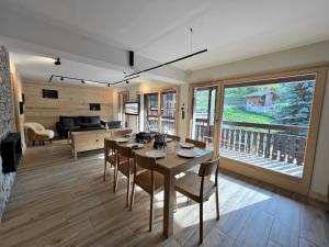 a living room with a table and chairs and a couch at OURS POLAIRE bel appartement village et pistes in La Clusaz
