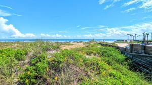 a beach with a wooden fence and the ocean at Beach Escape by Casago in Saint Augustine Beach