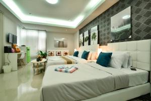 a large bedroom with two beds and a table at Sphat เอสพลัส Boutique Hotel chiang mai in Chiang Mai