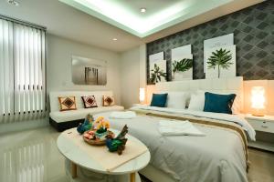 a bedroom with two beds and a table and a couch at Sphat เอสพลัส Boutique Hotel chiang mai in Chiang Mai