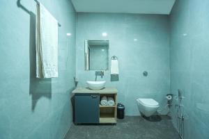 Hotel Grand Cabbana By Levelup Hotels في أمريتسار: حمام أزرق مع حوض ومرحاض