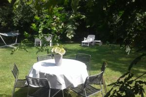 een witte tafel met stoelen en een vaas met bloemen bij THE FACTORY, retreat near Bruges in Zedelgem