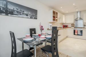 a kitchen and dining room with a table and chairs at MPL Apartments - Queens Broadway F4 in Watford