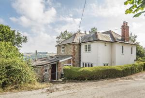 ein altes Backsteinhaus am Straßenrand in der Unterkunft Ryall Hope Cottage in Bridport