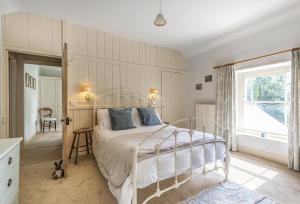 a bedroom with a white bed and a window at Ryall Hope Cottage in Bridport