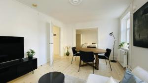 - un salon blanc avec une table et des chaises dans l'établissement ApartmentInCopenhagen Apartment 1514, à Copenhague