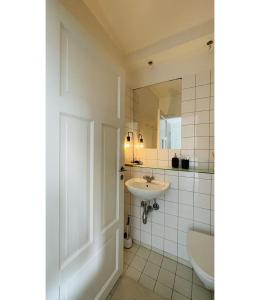 La salle de bains est pourvue d'un lavabo et d'un miroir. dans l'établissement ApartmentInCopenhagen Apartment 1514, à Copenhague