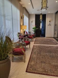 a lobby with tables and chairs and a hallway with rugs at Ambassador, a Boutique Hotel in Amman