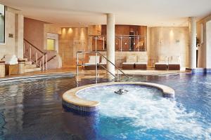 a pool in a building with a swimming pool at Whatley Manor in Malmesbury