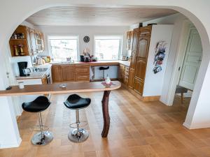 a kitchen with a wooden table and two bar stools at Marna Guesthouse doubleroom nr.2 in Tórshavn