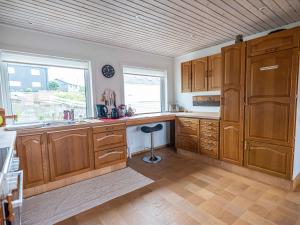a large kitchen with wooden cabinets and a window at Marna Guesthouse doubleroom nr.2 in Tórshavn