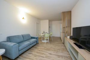 - un salon avec un canapé bleu et une table dans l'établissement Residence Sunlight, à Lido di Jesolo