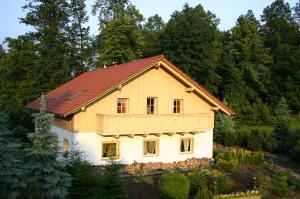 uma casa com um telhado vermelho numa floresta em Tyrolska Zagroda Apartament em Karpacz