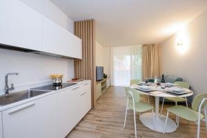 - une cuisine et une salle à manger avec une table et des chaises dans l'établissement Residence Sunlight, à Lido di Jesolo