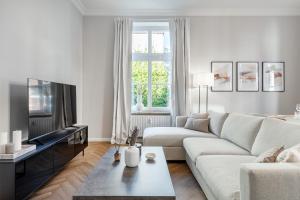 sala de estar blanca con sofá y TV en Apartment Villa Anna - Wohnung mit Stellplatz, en Emden