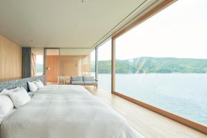 a large bed in a room with a large window at Entô in Ama