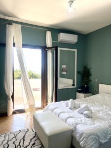 a bedroom with a large bed and a large window at Villa Kastro Elassona in Elassona