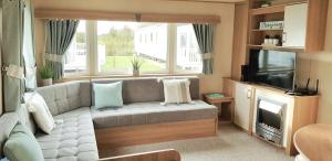 a living room with a couch and a television at Living Easy Staycations at Tattershall Lakes in Tattershall