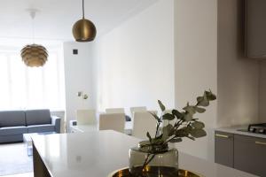 a kitchen with a table with a vase with a plant in it at 2ndhomes Luxury 3 BR Brand New 106 m2 Apartment with Spa in Helsinki Center in Helsinki +14 photos