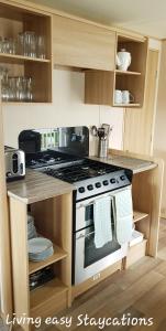 a kitchen with a stove top oven in a kitchen at Living Easy Staycations at Tattershall Lakes in Tattershall