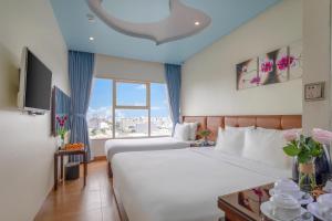 a hotel room with a bed and a large window at FIVITEL King in Da Nang