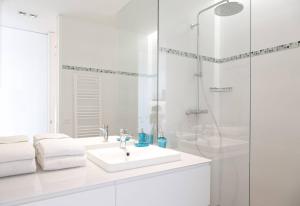 Arc de Triomphe Apartment في باريس: حمام أبيض مع حوض ودش +11 صورة