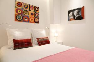 Arc de Triomphe Apartment في باريس: سرير أبيض مع وسادتين في غرفة النوم