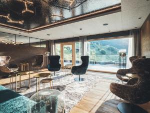 a room with chairs and tables and a large window at Hotel Tirolerhof 4 Sterne Superior in Tux