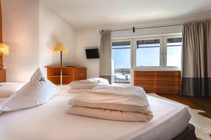 two beds in a hotel room with a window at Residence Hotel Alpinum in Campo Tures +154 photos