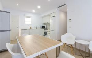 デニアにある3 Bedroom Awesome Apartment In Deniaのキッチン(木製テーブル、白い椅子付)