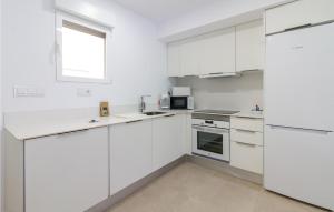 デニアにある3 Bedroom Awesome Apartment In Deniaの白いキャビネットと窓付きの白いキッチン