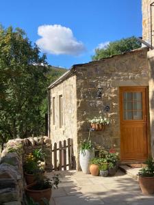 a small stone building with a door and some plants at The Dale at Greystones - Luxurious annexe with stunning view in Buckden