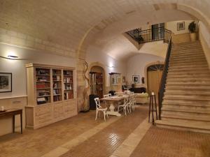 a large room with a staircase and a table with chairs at B&B Giardino delle Delizie in Gravina in Puglia