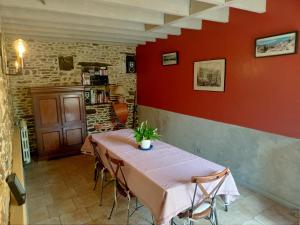 une table dans une pièce avec un mur rouge dans l'établissement Au Mont & Merveilles, à Sartilly