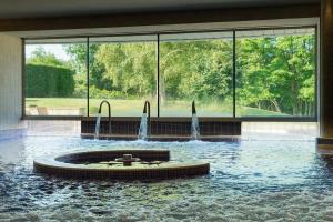 a fountain in the middle of a pool of water at Whatley Manor in Malmesbury