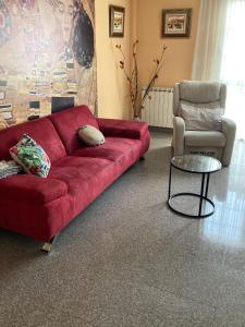 czerwona kanapa i krzesło w salonie w obiekcie La Mirada de Monreal w mieście Monreal del Campo