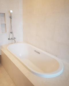 a white bath tub sitting in a bathroom at Baan Maikhao pool villa in Mai Khao Beach
