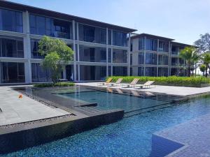 a building with a swimming pool in front of a building at Baan Maikhao pool villa in Mai Khao Beach