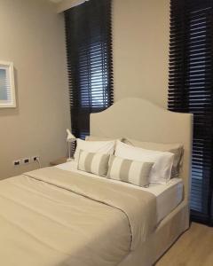 1 dormitorio con cama blanca y almohadas blancas en Baan Maikhao pool villa, en Mai Khao Beach