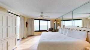 um quarto com uma grande cama branca e janelas grandes em Beachside II 4295 em Destin